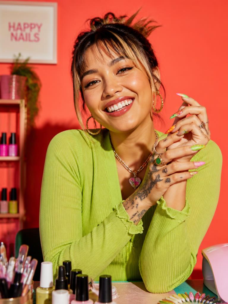 Nail artist laughing in a coral-toned studio